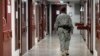 Гуантанамо түрмесінің дәлізінде кетіп бара жатқан күзетші. 5 наурыз 2013 жыл.