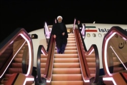 Rohani deplaning on an escalator in Tehran.