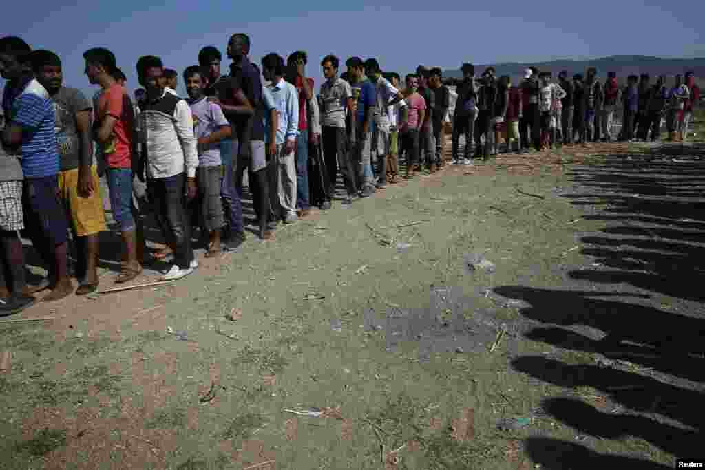 Migrants line up to receive sandwiches offered by volunteers outside a derelict hotel on the Greek island of Kos on August 17. (Reuters/​Alkis Konstantinidis)