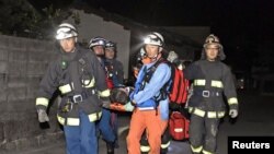 Рятувальники несуть людину, врятовану на завалах будинку в місті Машікі, префектура Кумамото, 15 квітня 2016 року