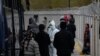 Un asistent medical examinează migranții care au ajuns în Grecia din Turcia prin Marea Egee, 5 martie, 2020