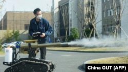 Član osoblja upravlja robotom za dezinfekciju ulica u gradu Robot u gradu Hangzhou u kineskoj provinciji Zhejiang 