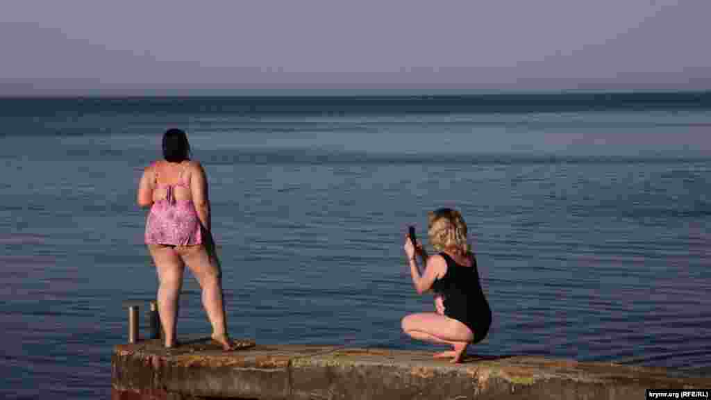 Девушки фотографируются на фоне водной глади