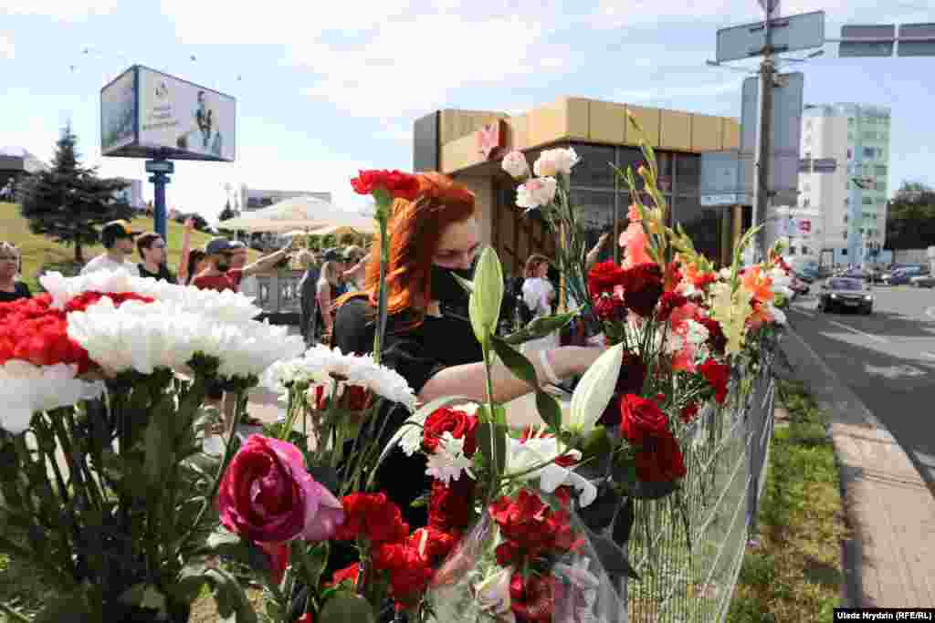 A woman places flowers at the site where the Belarusian protester died in Minsk.