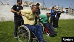 Палестиналық паралимпиадашы Хамис Закот (сол жақта) басқа да мүмкіндігі шектеулі спортшылармен бірге жаттығады. Газа қаласы, 28 мамыр 2012 жыл. (Көрнекі сурет)