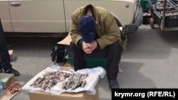 В Керчи рыбак продаёт свежую рыбу. Июль 2014 года.