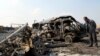 A resident stands near burned vehicles after a car-bomb attack in Baghdad's Kadhimiyah district on February 8.