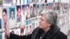 Kosovo - Nesrete Kumnova, head of the Mothers Appeal Association, in front of a wall with photos of missing people in Pristina, Nov2007