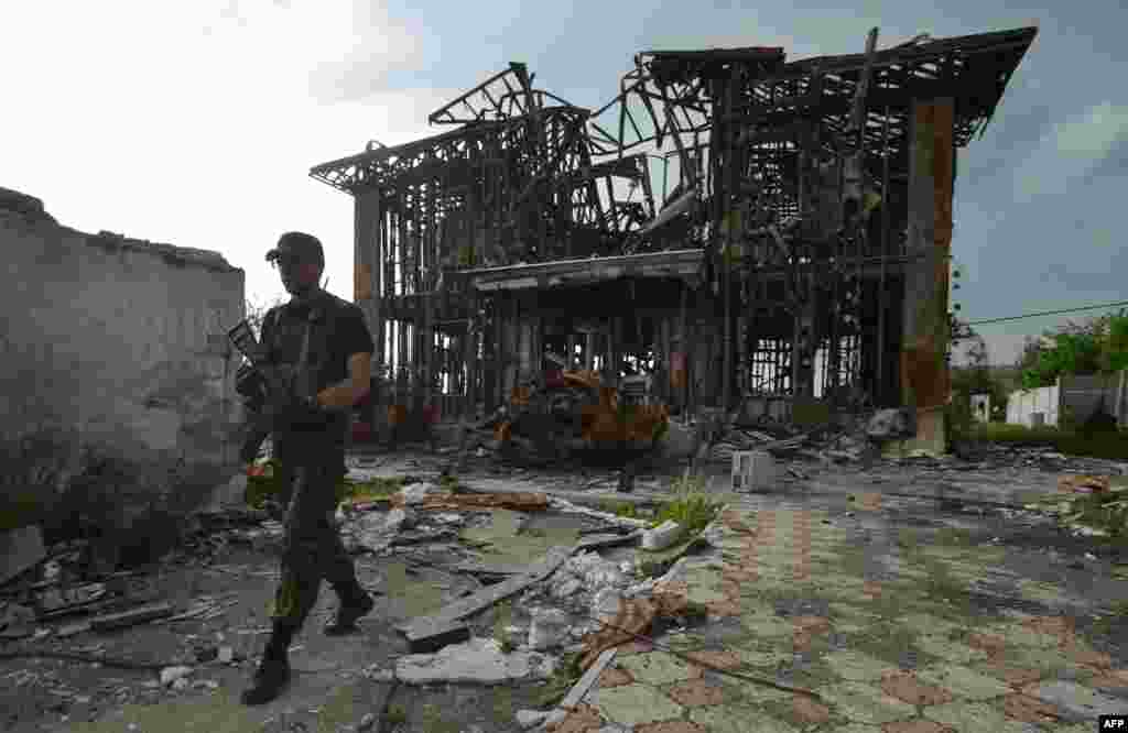 A Ukrainian serviceman walks past a destroyed house on the front line facing pro-Russian separatists near Donetsk. (AFP/Genya Savilov)