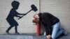 Graffiti în New York atribuit artistului Banksy.