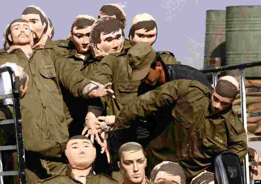 Dummies depicting Israeli soldiers are unloaded from a truck during the shooting of a movie telling the story of a member of Shi'ite movement Hezbollah. (AFP/Mahmoud Zayyat)