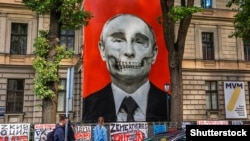 Krišs Salmanis művész Vlagyimir Putyin orosz elnököt ábrázoló képe a lettországi orosz nagykövetség előtt július 9-én