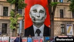 An image of Russian President Vladimir Putin by the artist Kriss Salmanis hangs outside the Russian Embassy in Latvia on July 9.