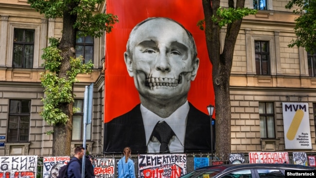 Плакат с изображением Владимира Путина, висевший несколько месяцев напротив здания посольства РФ в Латвии