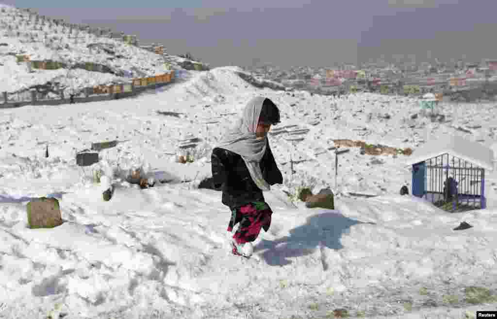 Afghanistan -- A girl walks in a snow-covered cemetery in Kabul, 18Dec2012