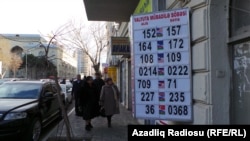 Прохожие рядом с пунктом обмена валют в Баку. 21 декабря 2015 года.