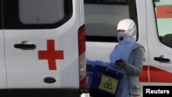 A medical staff member wearing a protective suit walks near a hospital where coronavirus patients are being treated in Moscow on March 17.