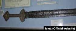 На фотографії меч, розміщений в експозиції Національного музею історії України, який отримав назву «Коваль Людота». Цей меч був знайдений у 1890 році на Полтавщині, його датують ХІ століттям