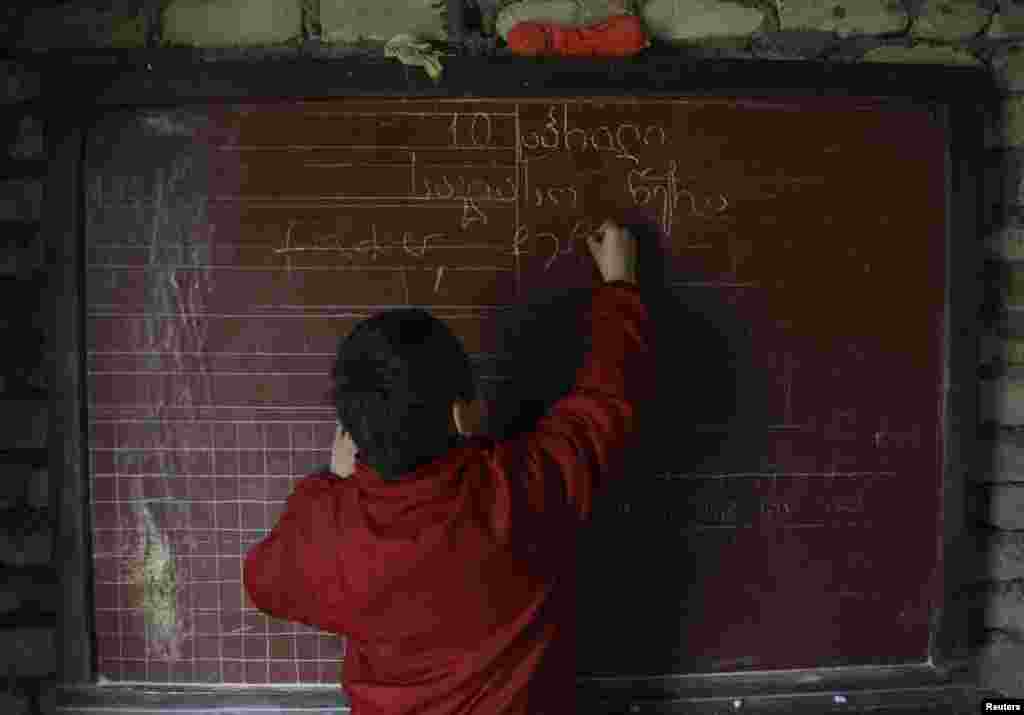Bacho writes on a chalk board.