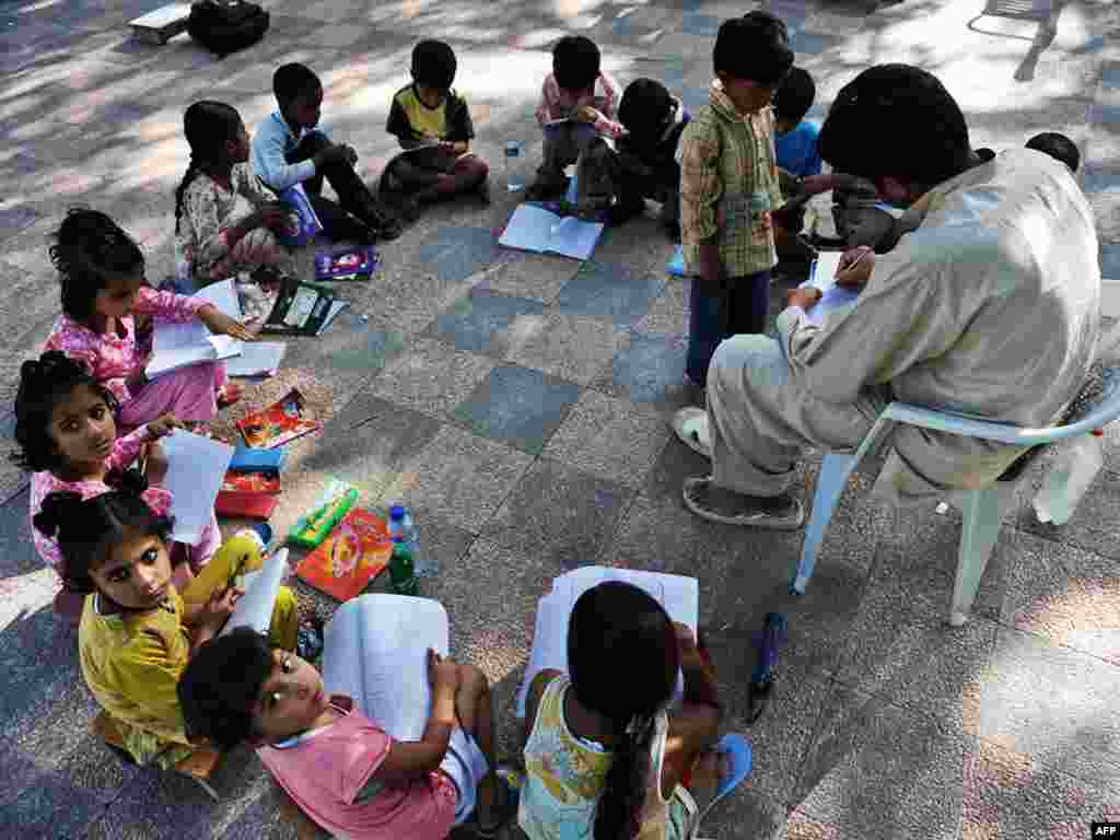 Pakistan -- Pakistani pupils attend class at a school situated in a park in Islamabad, 08Sep2009 - PAKISTAN, Islamabad : Pakistani pupils attend class at a school situated in a park in Islamabad on September 8, 2009. About 45 percent or over 50 million people in Pakistan are illiterate. Half of rural women cannot read or write, officials media reports said. universal primary education green03