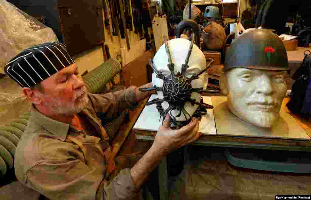 Blacksmith, artist, and teacher Sergei Kolchin works on a collection of forged headwear for busts of Soviet state founder Vladimir Lenin while creating works for his solo exhibition at a workshop in the Siberian city of Krasnoyarsk. (Reuters/Ilya Naymushin)