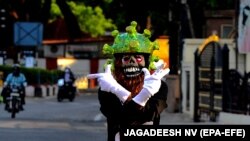 India: un polițist în trafic, în Bangalore, poartă o cască în formă de coronavirus, în efortul de a convinge oamenii să rămână acasă. Prim-ministrul indian Narendra Modi a dispus restricții pe parcursul a 21 de zile, începând cu miezul nopții de 24 martie, pentru a stopa răspândirea coronavirusului.