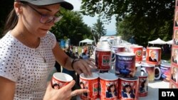 Жена подрежда чаши с образа на Тодор Живков и Корнелия Нинова на традиционния събор на БСП на Бузлуджа, 2019 г.