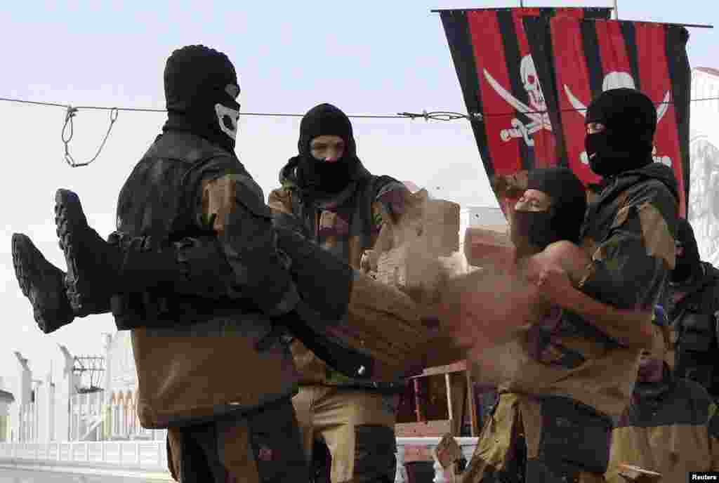 A member of the Pokrov youth military-patriotic club crushes a pile of bricks with a hammer atop the stomach of a comrade as they demonstrate their skills at Siberian Venice Park outside the Siberian town of Sosnovoborsk. (Reuters/Ilya Naymushin)