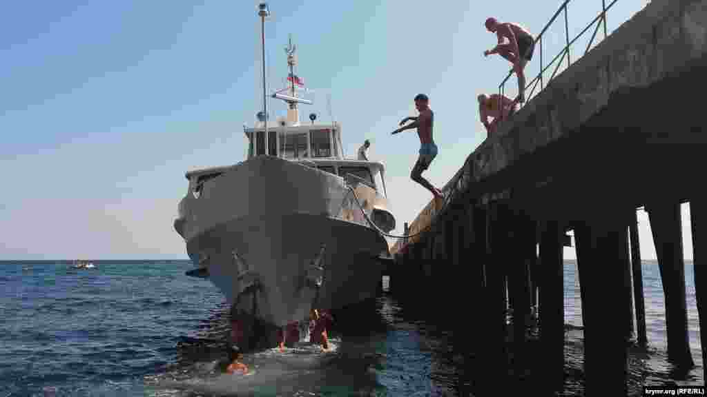 Діти стрибають у море з пірсу в Гурзуфі