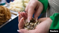 Женщина считает деньги на рынке в Алматы. Иллюстративное фото.