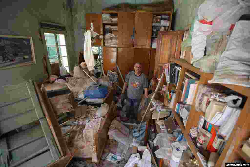 Naji Ghouma stoji u gomili smeća u svojoj oštećenoj kući u naselju Gemmayze