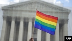 یکی از طرفداران حق ازدواج همجنسگرایان پرچم دگرباشان را در برابر دیوان عالی آمریکا در دست دارد. ۲۶ مارس ۲۰۱۳.