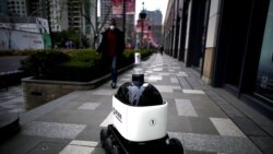 Робот, который предлагает прохожим санитайзер для рук, Шанхай, март 2020 года