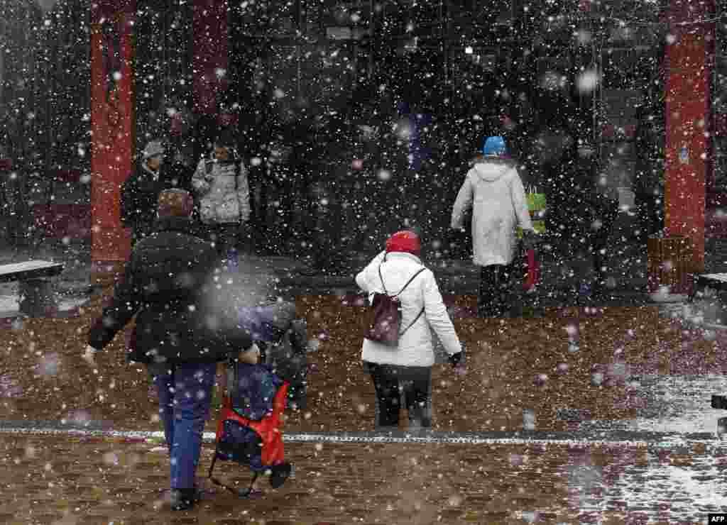 Residents walk through the snow to vote. 