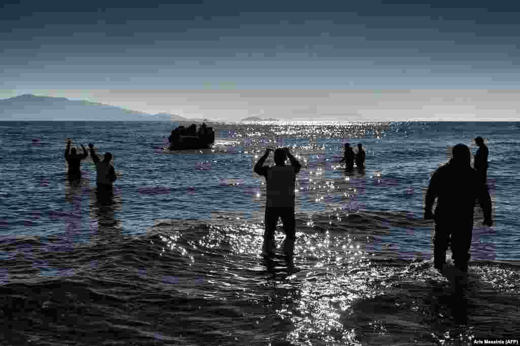 Members of the non-profit Emergency Response Centre International (ERCI) gesture to a boat carrying migrants as it arrives in Mytilene on the northern Greek island of Lesbos after crossing the Aegean sea from Turkey on February 22. (AFP/Aris Messinis)