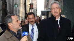 A reporter from Iranian television (left) asks a question of U.S. diplomat William Burns as he leaves a meeting of major powers on January 16.