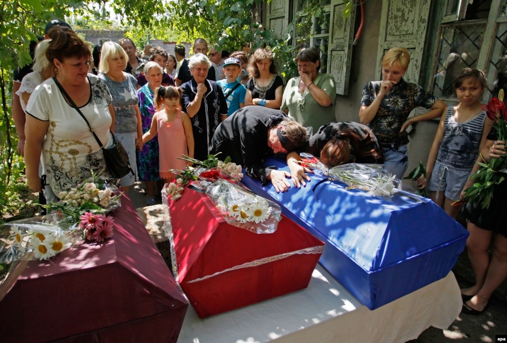 Родичі плачуть на трунах загиблих дітей під час церемонії похорону в Єнакієвому Донецької області у липні 2016 року. Як тоді повідомила Спеціальна моніторингова місія ОБСЄ в Україні, діти знайшли гранату і принесли її додому. Удома граната вибухнула &ndash; осколками вона поранила батька і вбила трьох його дітей &ndash; 11, 5 і 1,5-річного віку.