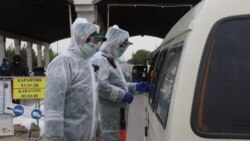 Коронавирус пандемиясына байланысты карантин кезінде көлікті тексеріп тұрған адамдар. Самарқан, Өзбекстан, 15 сәуір 2020 жыл.