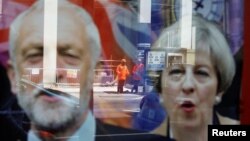 Theresa May və Jeremy Corbyn-in seçki plakatları vitrində əks olunur