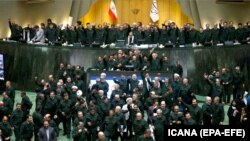 Wearing the uniform of the Iranian Revolutionary Guard, lawmakers chant slogan during an open session of parliament in Tehran, April 9, 2019