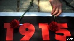 Turkey -- A person lays a carnation on a printed sign during a demonstration marking the 98th anniversary of the massacre and deportation of Ottoman Armenians during World War I, Istanbul, 24Apr2013