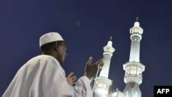 A Muslim pilgrim prays outside the Grand Mosque in Mecca, Saudi Arabia. Under King Abdullah, the kingdom has moved toward a more inclusive form of Islam.