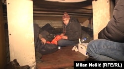 Refugees and migrants, mostly from Afghanistan and Pakistan, seek shelter under a stairwell near the Belgrade bus station in February 2017.