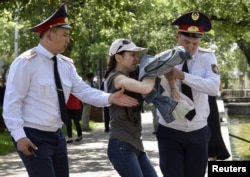 Полиция қызметкерлері алаңға келген адамды әкетіп бара жатыр. Алматы, 23 маусым 2018 жыл.