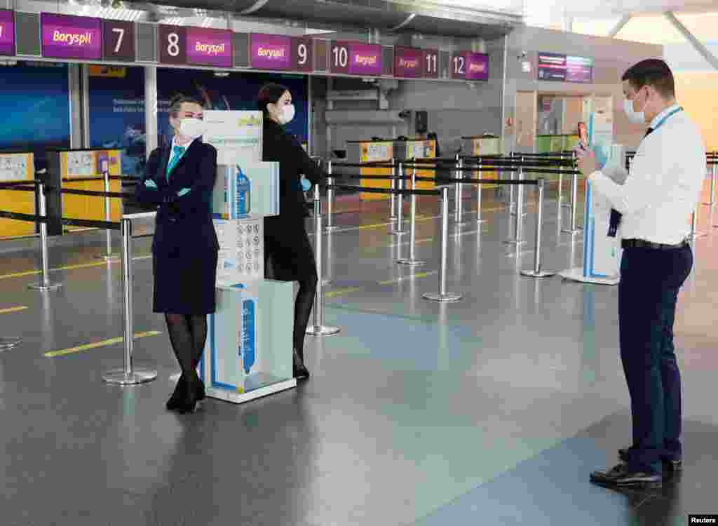 Працівник аеропорту &laquo;Бориспіль&raquo; фотографує своїх колег на пункті пропуску після відновлення пасажирських авіаперевезень в Україні