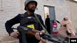 Pakistani security officers escort heath workers as they administer polio vaccinations to children in Peshawar last month.