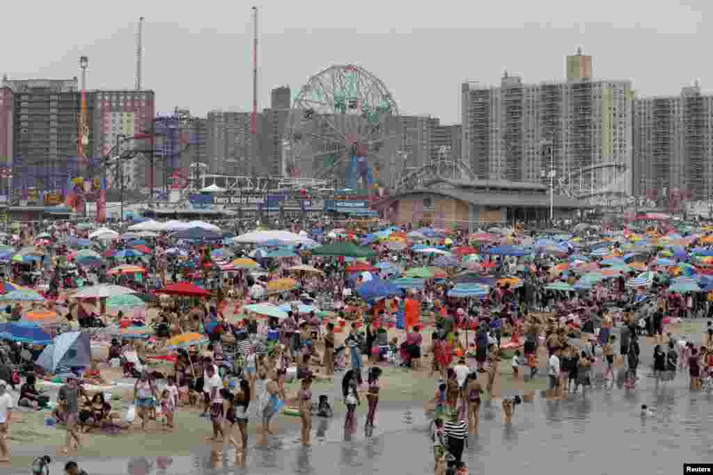 Люди збираються на пляжі Коні-Айленда, щоби відсвяткувати 4 липня в Нью-Йорку