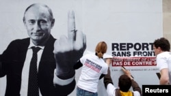 "Репортеры без границ" вывешивают плакат с изображением Владимира Путина. Жест символизирует его отношение к свободе прессы