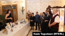 Дочь Айдархана Даулбаева, Даяна, представляет гостям 60-летнего юбилея ее отца полученные им награды и грамоты. Алматы, 16 декабря 2019 года.