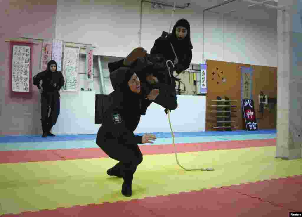 A woman swings from a rope to attack.